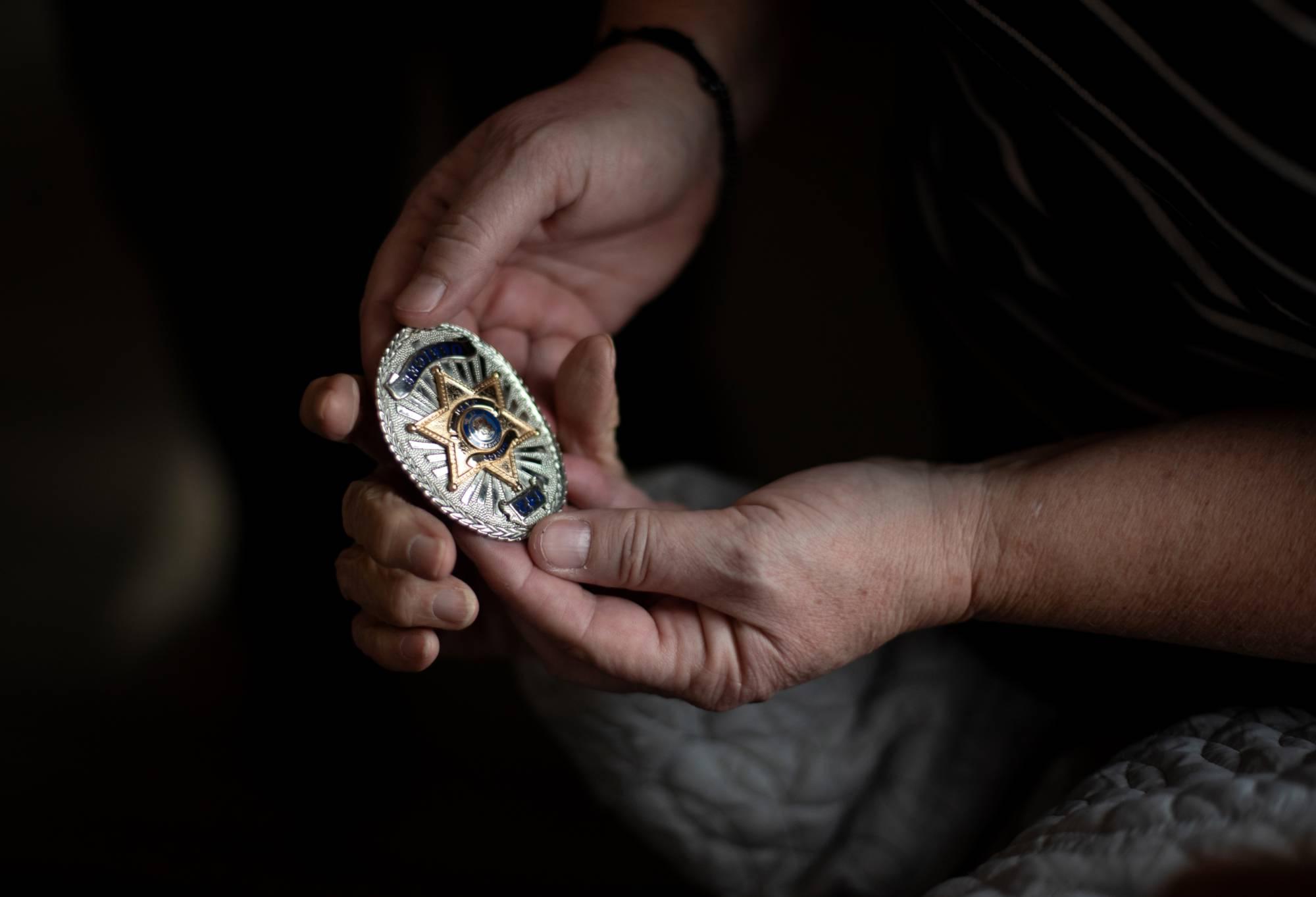 hands holding badge. click to see the criminal justice undergraduate program